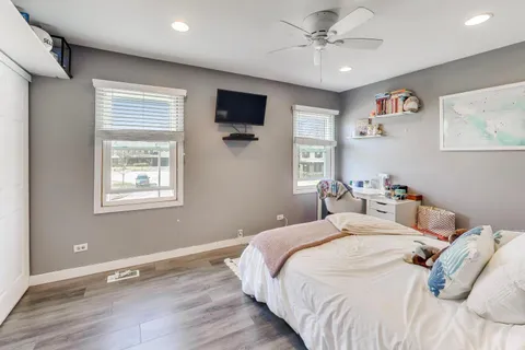 a bedroom with bed tv and a window