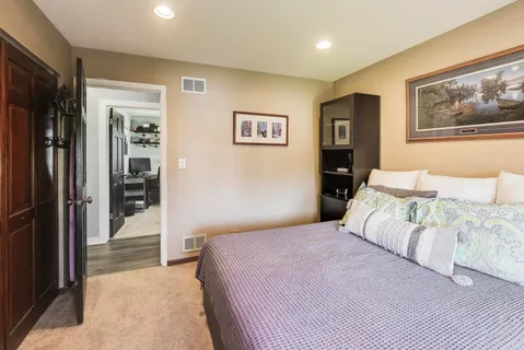 a bedroom with a large bed and a painting on the wall