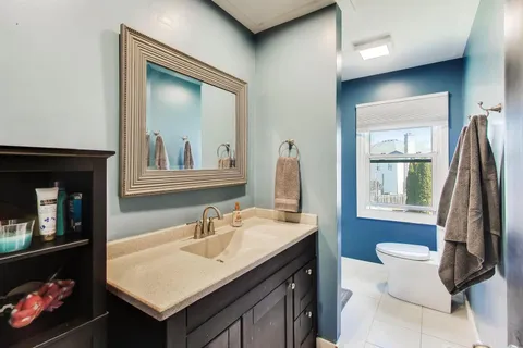 a bathroom with a sink a toilet and a window