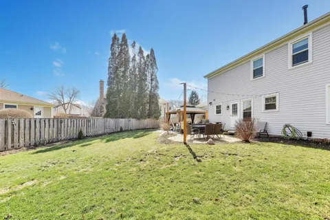 a backyard of a house with table and chairs