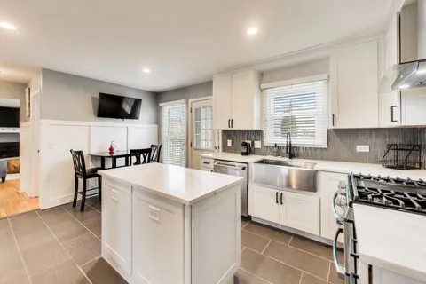a kitchen with white cabinets and white appliances