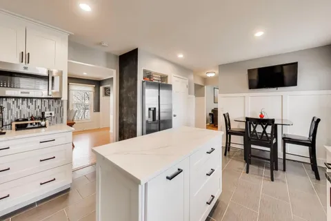 a large kitchen with a table and chairs
