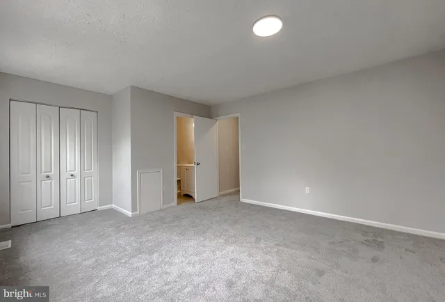 a view of an empty room and closet area
