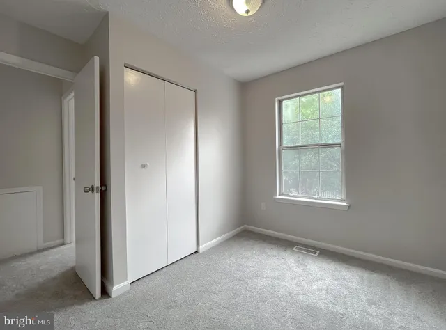 an empty room with windows and closet