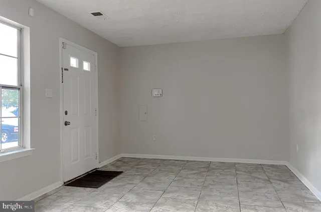an empty room with windows and entrance