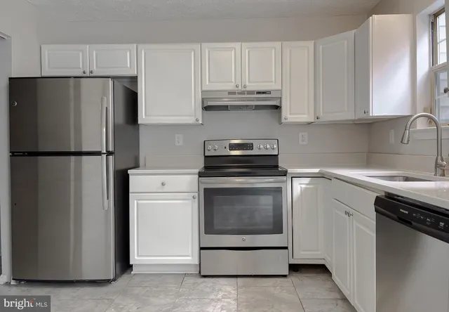 a kitchen with cabinets and stainless steel appliances