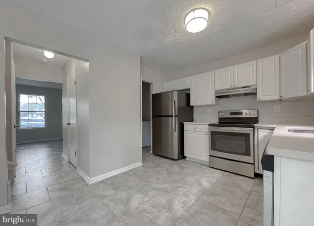 a kitchen with a refrigerator and a stove