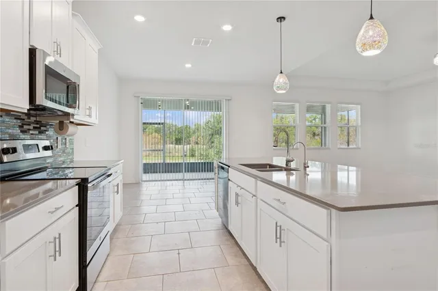 a kitchen with stainless steel appliances granite countertop a stove a sink and a microwave