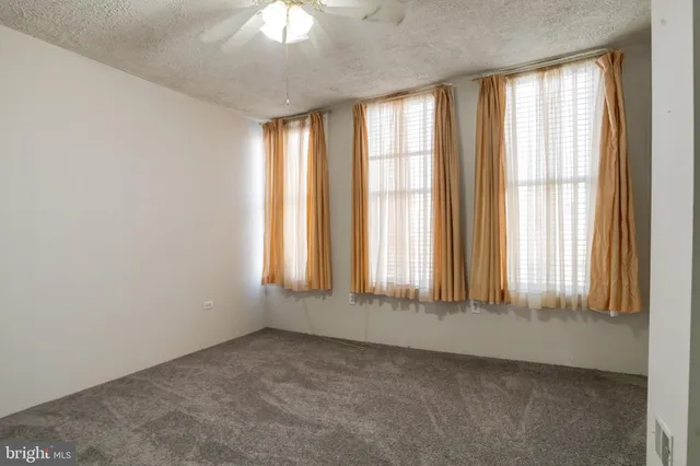 an empty room with a empty space and a ceiling fan
