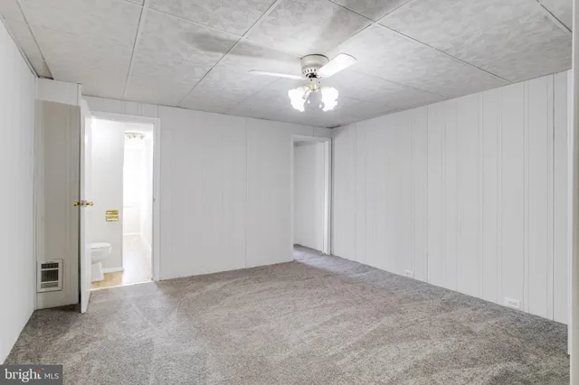 an empty room with closet and a ceiling fan