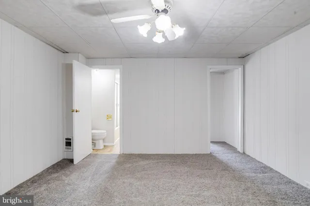 an empty room with closet and a ceiling fan