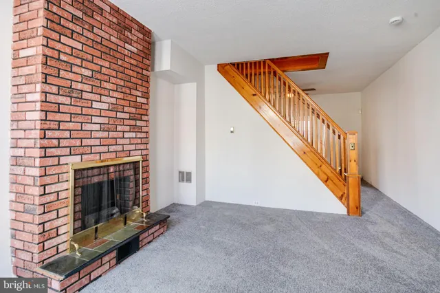an empty room with a fireplace and window