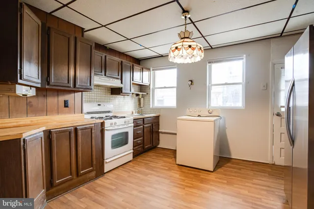 a kitchen with a refrigerator sink stove and cabinets