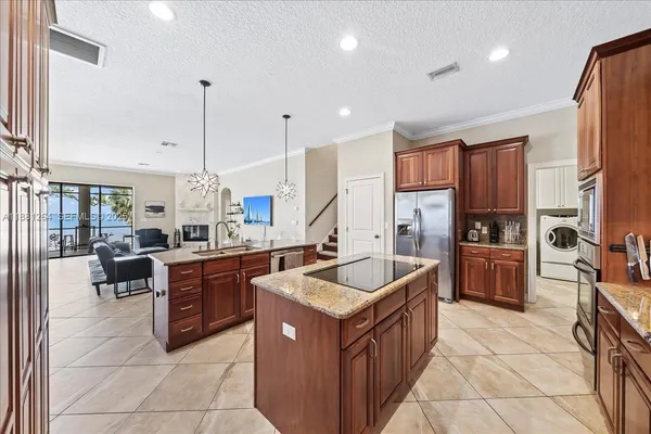 a kitchen with stainless steel appliances granite countertop a stove a sink a oven and a refrigerator
