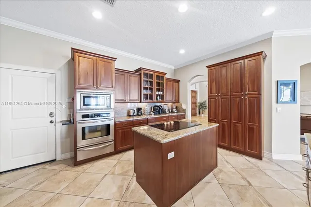 a kitchen with a sink a counter cabinets and a chandelier