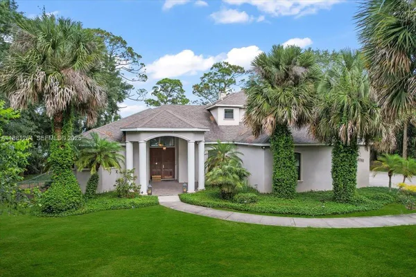 a front view of a house with a garden and plants