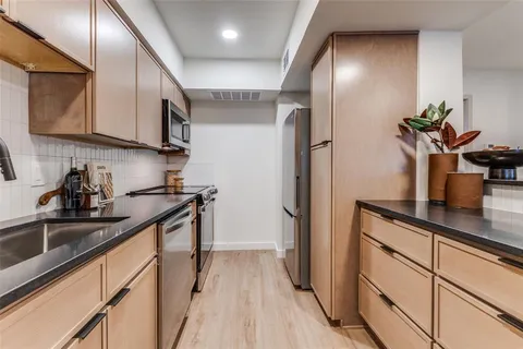 a kitchen with stainless steel appliances a sink and cabinets