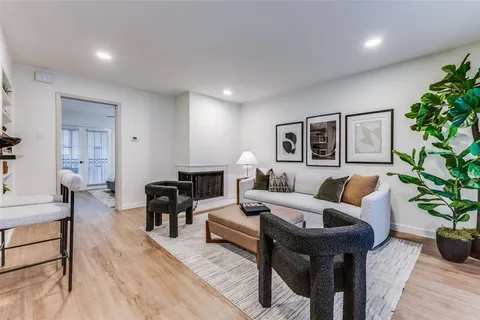 a living room with furniture potted plant and wooden floor