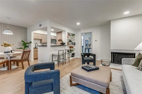 a living room with furniture and a view of kitchen