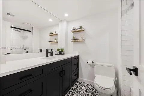 a spacious bathroom with a sink a toilet a shower and a mirror