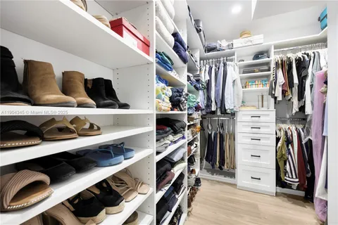 a view of walk in closet with clothes and shoes
