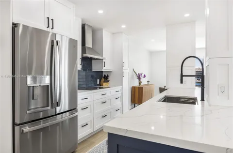 a kitchen with stainless steel appliances a refrigerator sink and cabinets