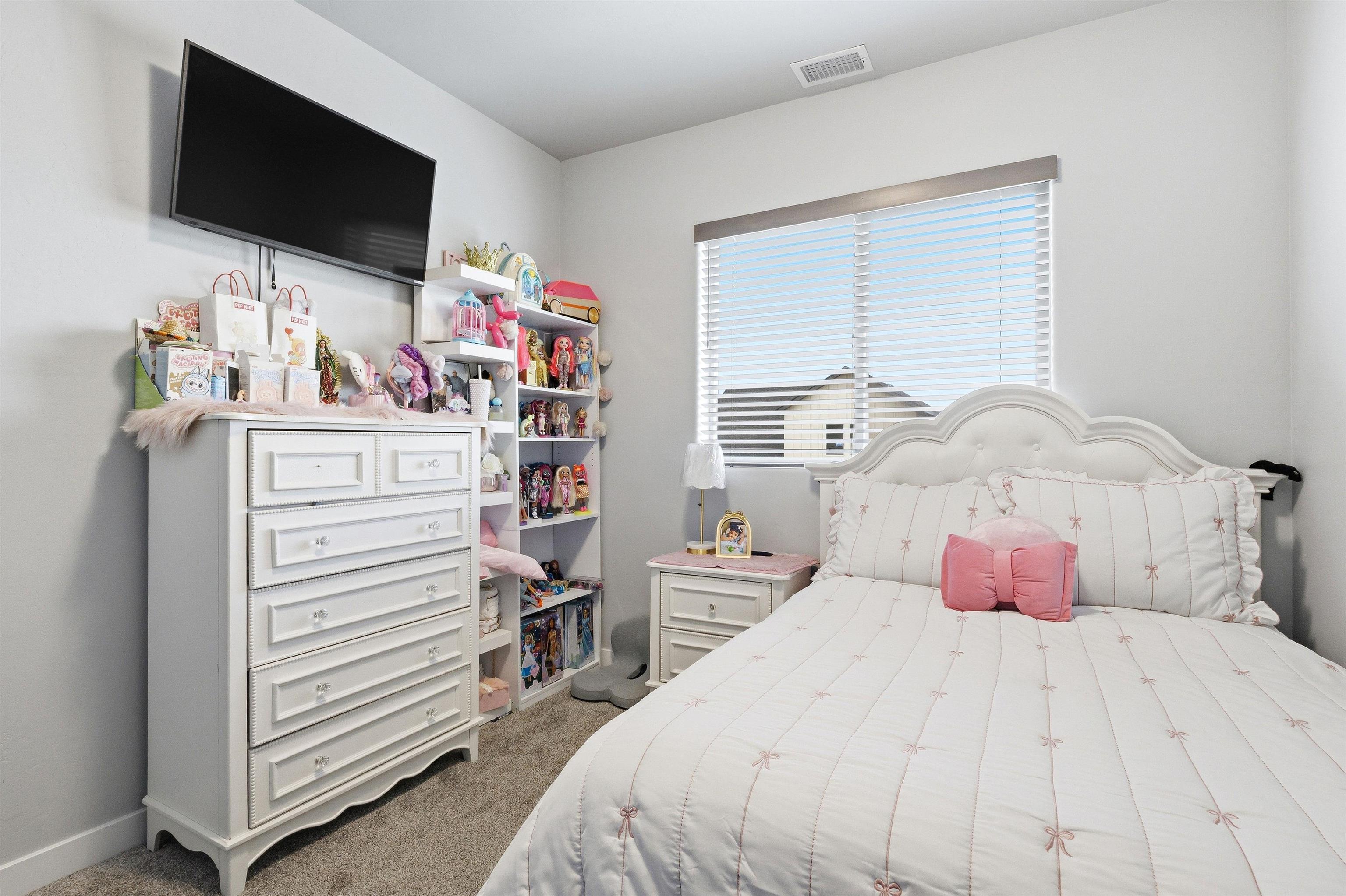 2459 Hamilton Road, Unit A Grand Junction, CO 81505 - Photo 23 of 27 a bedroom with a bed and flat screen tv