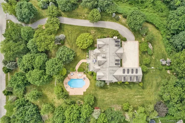 a aerial view of a house with a yard fountain and large tree