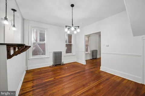 a view of a livingroom with wooden floor and staircase