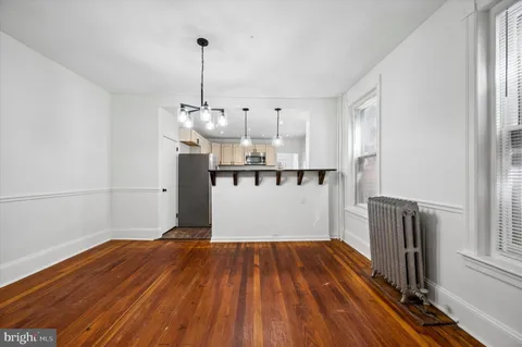 a view of empty room with wooden floor and window