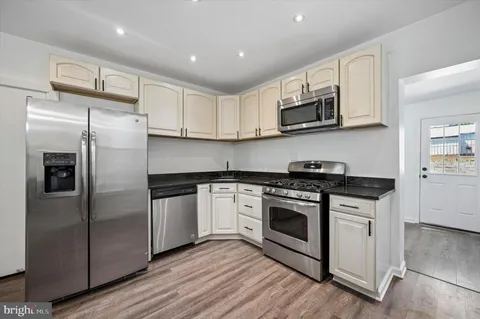 a kitchen with stainless steel appliances granite countertop a stove a refrigerator and a microwave