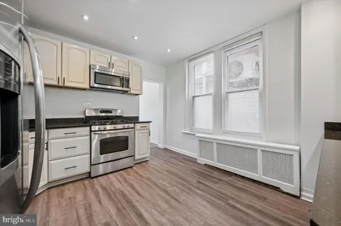 a kitchen with stainless steel appliances white cabinets and a sink