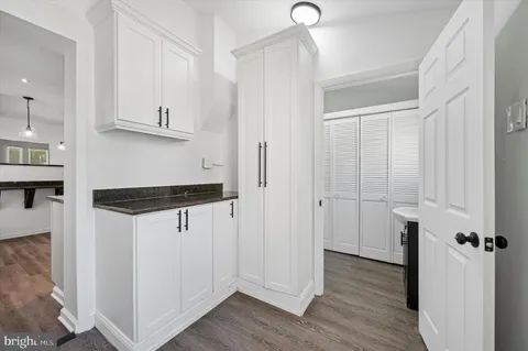 a kitchen with stainless steel appliances a refrigerator and a hard wood floor