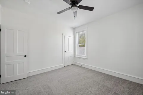 an empty room with chandelier fan