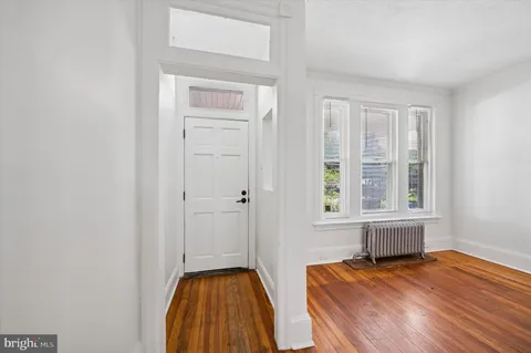 a view of bedroom with wooden floor and window