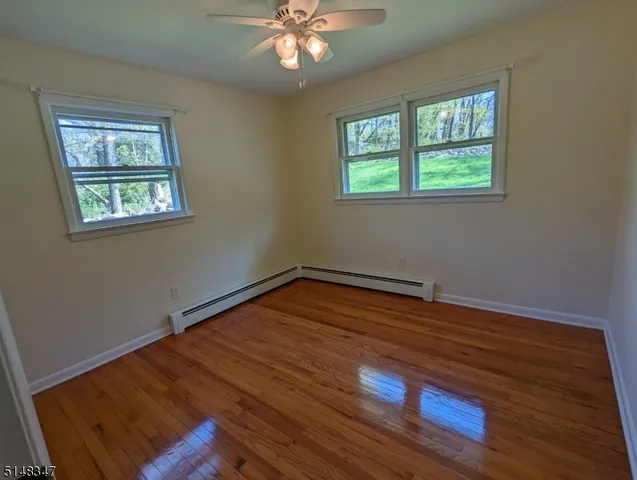 a room with wooden floor chandelier and windows