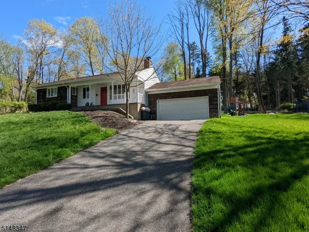 a front view of a house with yard and green space