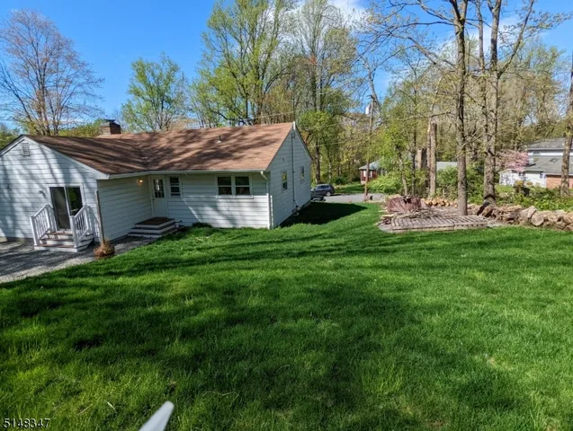 a front view of a house with a garden and trees
