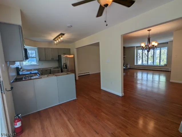 a kitchen with stainless steel appliances granite countertop a refrigerator a stove and a wooden floors