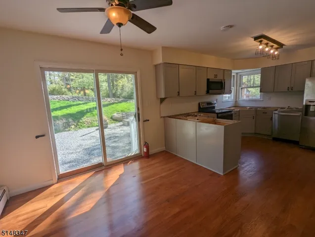 a kitchen with stainless steel appliances granite countertop a stove top oven a sink with a dining table and chairs