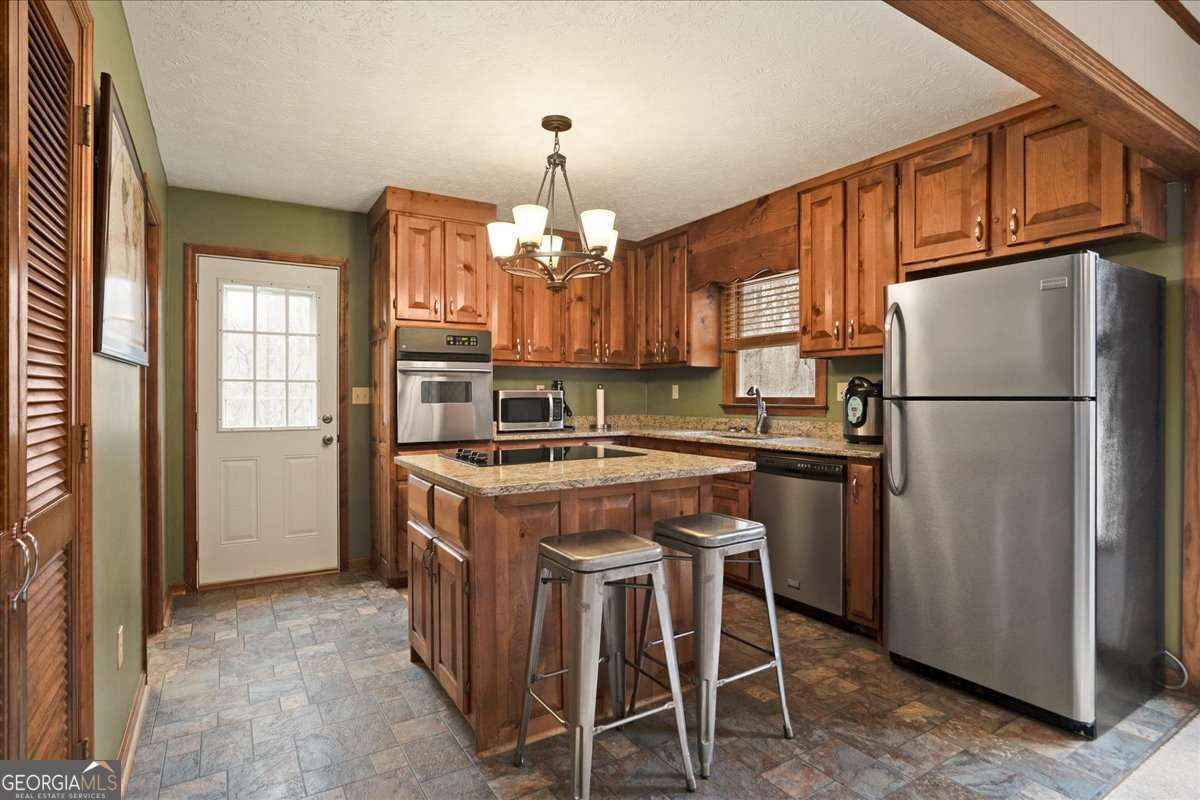 59 Busbin Lane Colbert, GA 30628 - Photo 12 of 29 a kitchen with refrigerator a stove and cabinets