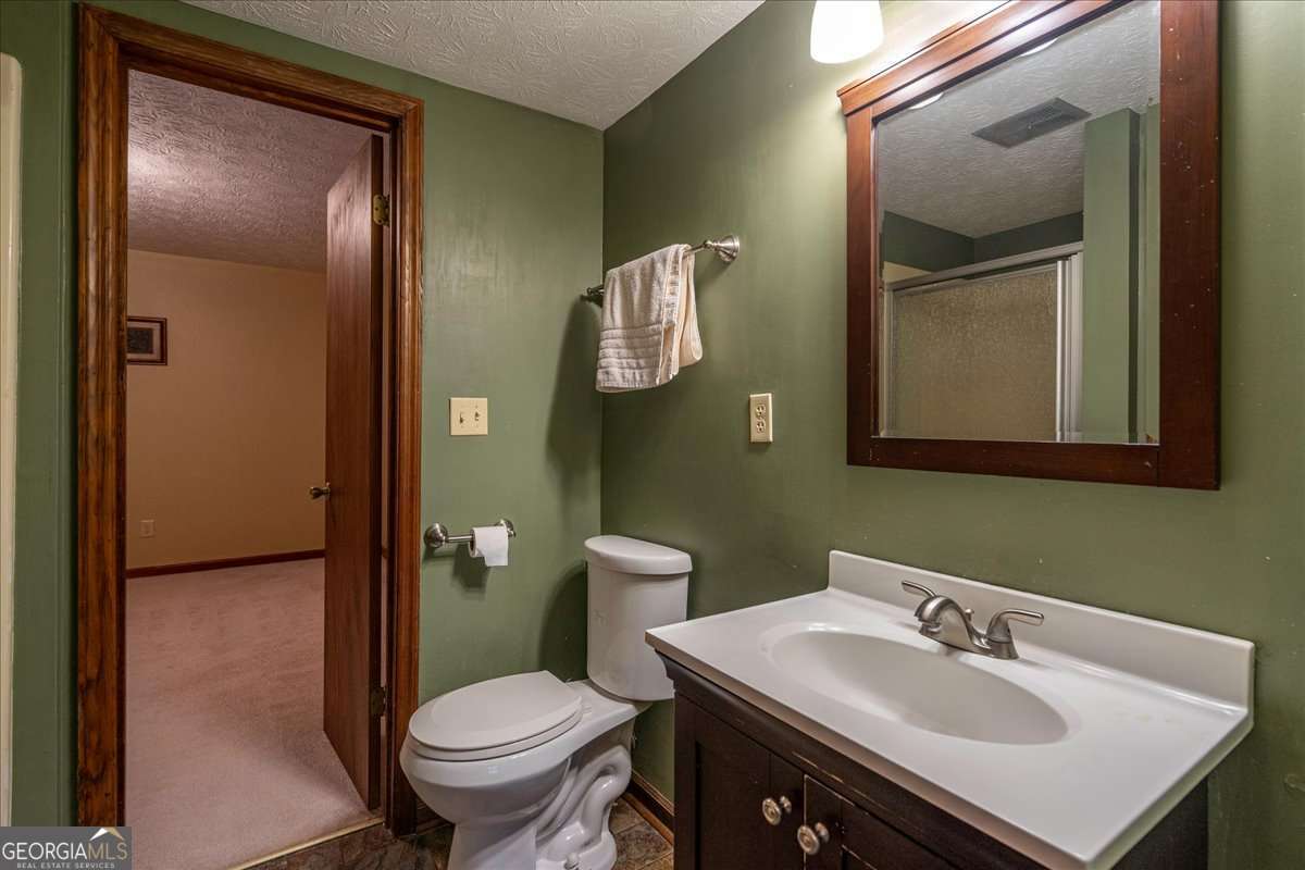59 Busbin Lane Colbert, GA 30628 - Photo 17 of 29 a bathroom with a sink toilet and mirror