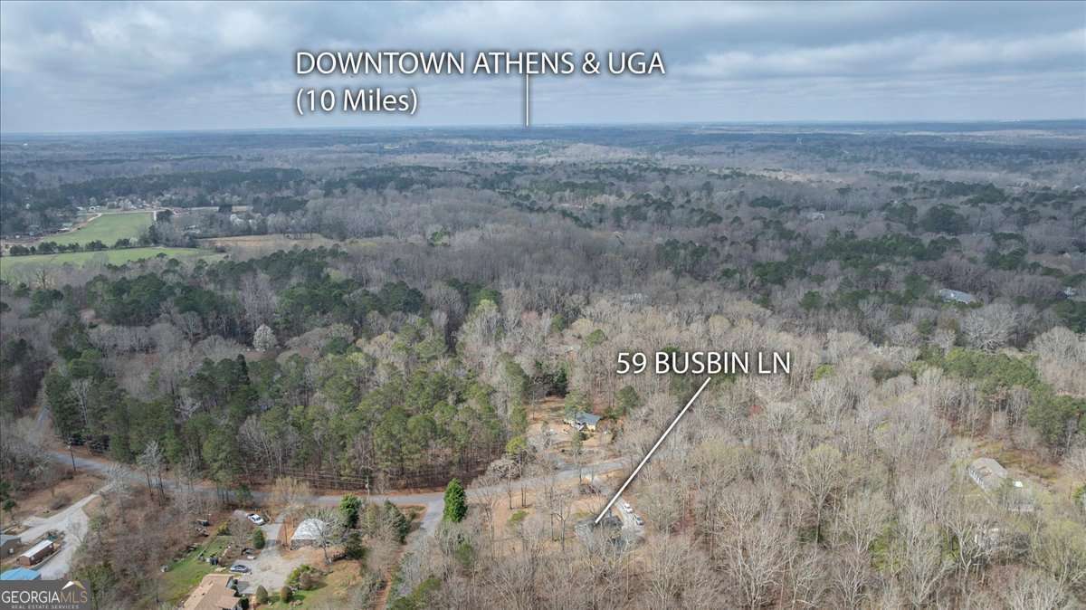 59 Busbin Lane Colbert, GA 30628 - Photo 6 of 29 a view of a dry yard with trees in the background