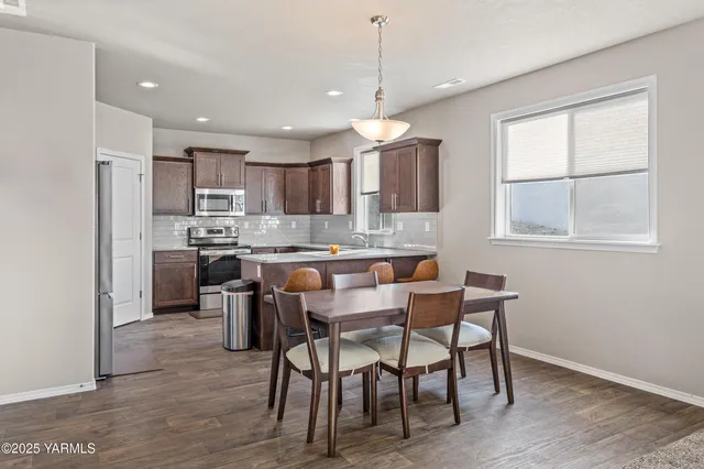 a kitchen with kitchen island a dining table and chairs