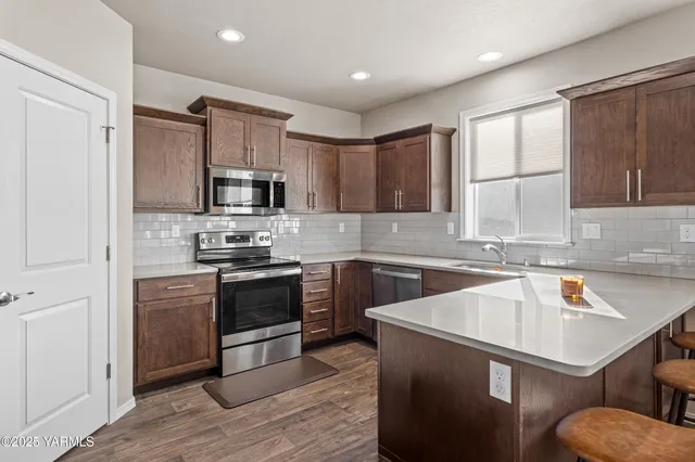 a kitchen with granite countertop a sink stove and refrigerator