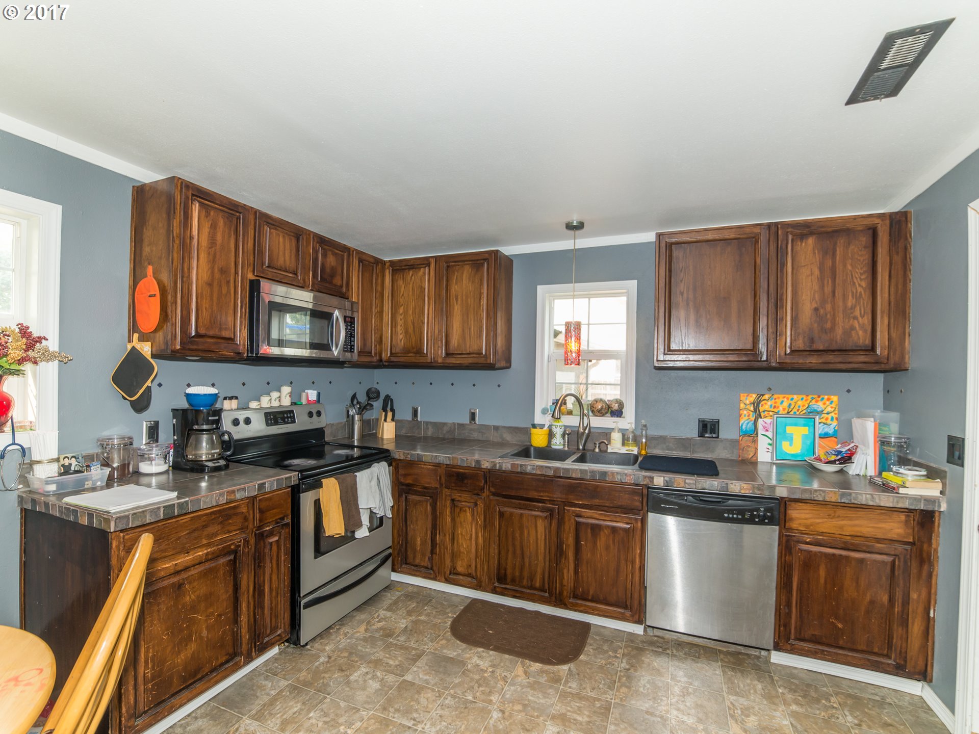 223 57th Street Springfield, OR 97478 - Photo 5 of 8 a kitchen with stainless steel appliances granite countertop wooden cabinets a stove top oven a sink and dishwasher