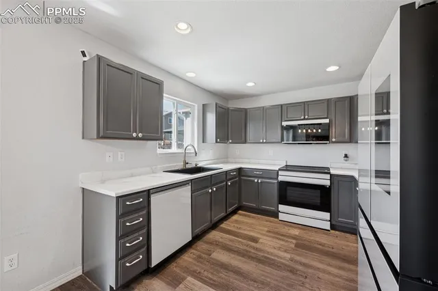 a kitchen with stainless steel appliances granite countertop a stove a sink and a refrigerator