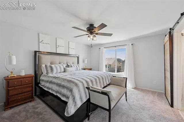a bedroom with a bed a chandelier and a dresser