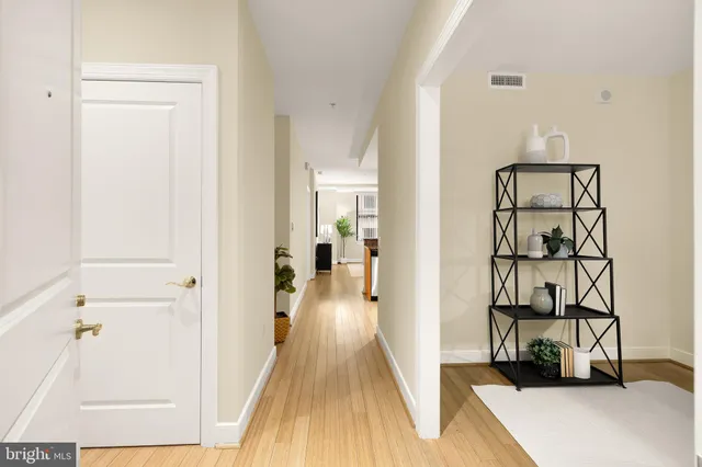 a view of a hallway with wooden floor and closet