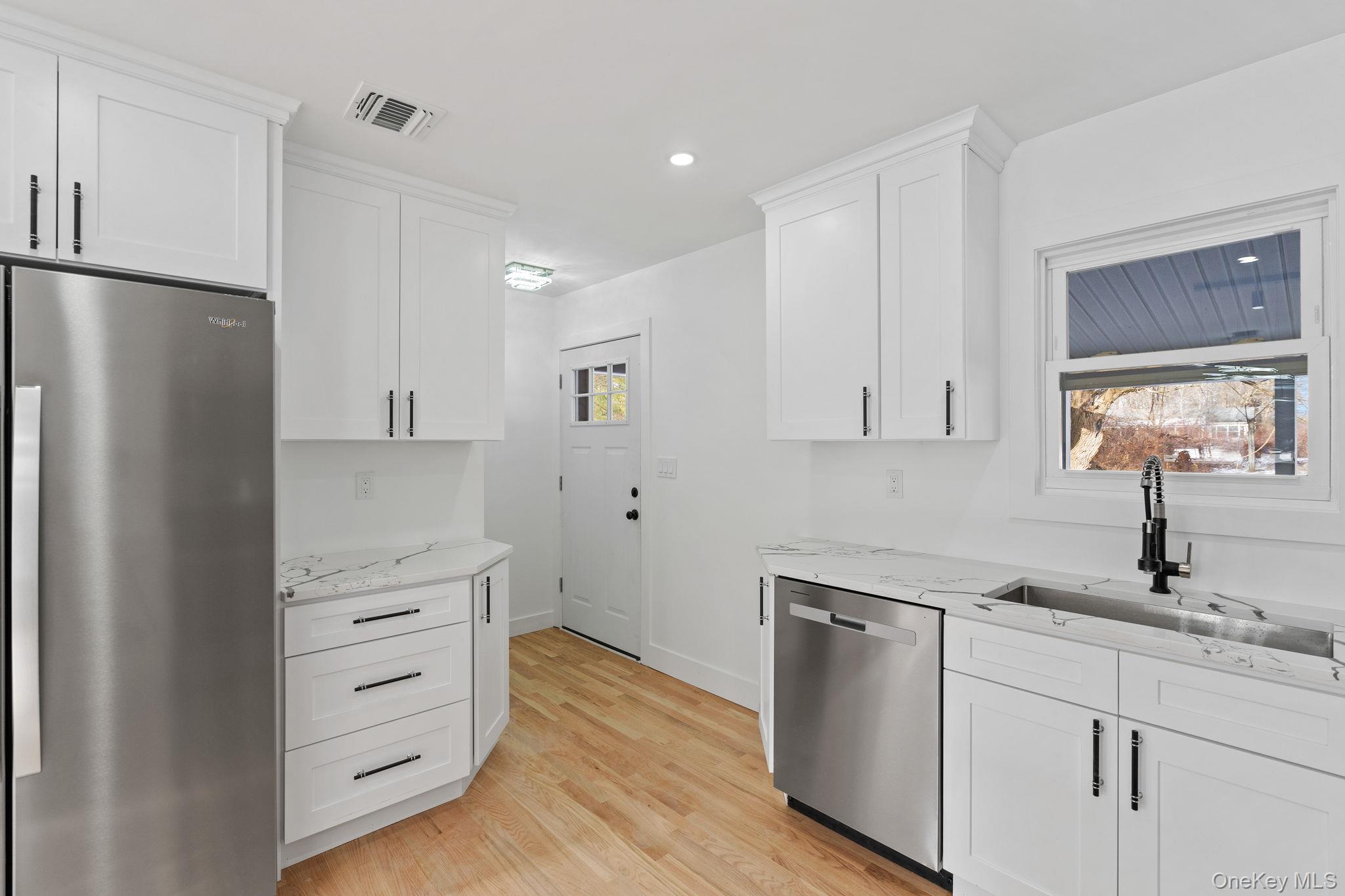 52 Rudolph Road Modena, NY 12548 - Photo 12 of 46 Kitchen featuring stainless steel appliances, white cabinets, light stone counters, recessed lighting, and light wood finished floors